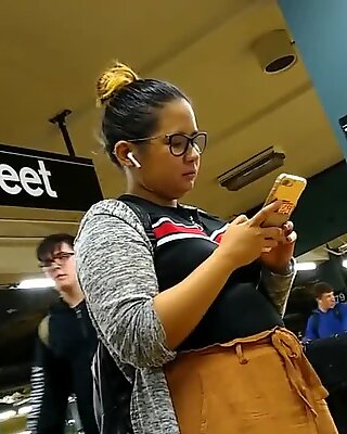 Cute chubby Filipina girl with glasses waiting for train